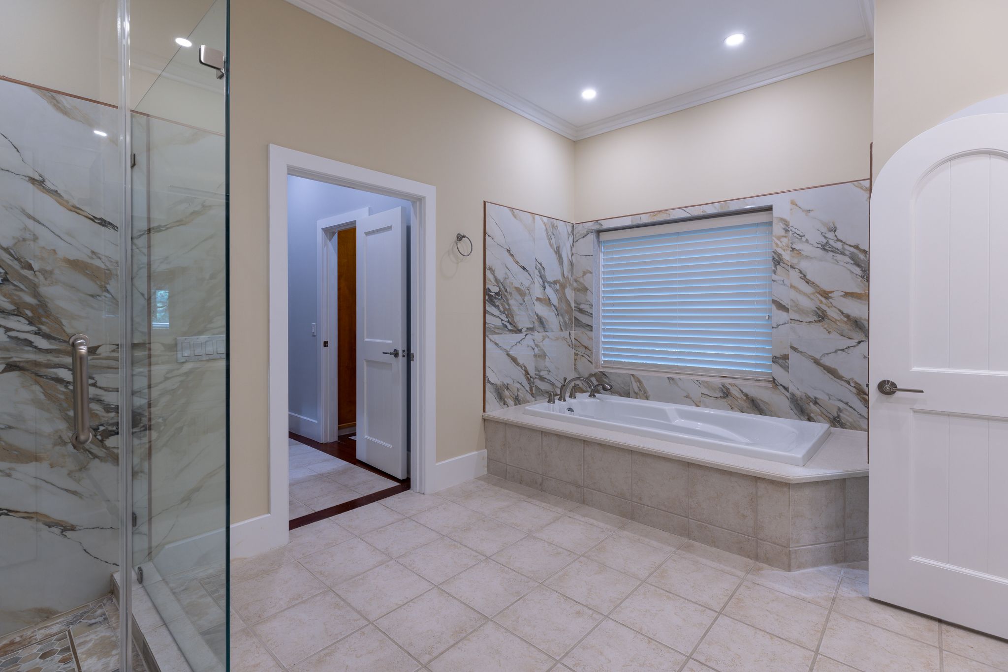 Freestanding soaking tub in the marble primary bath