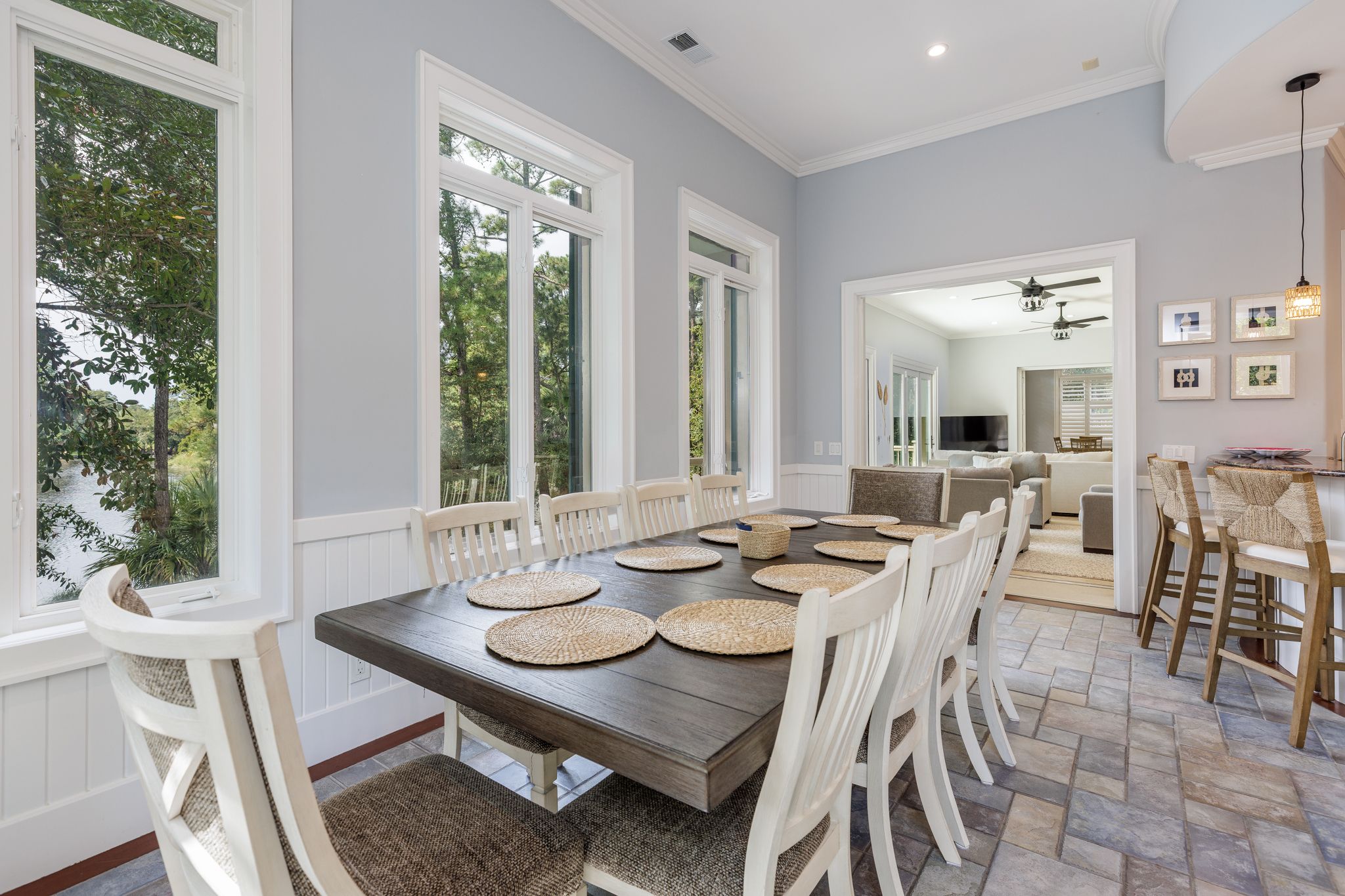 Oversized dining table by the windows with the kitchen bar beyond