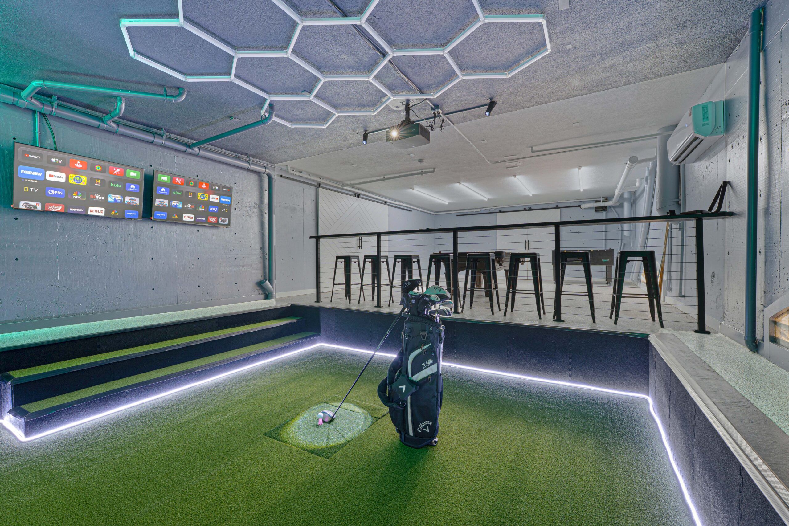 Golf simulator bar with screens set up for evening play