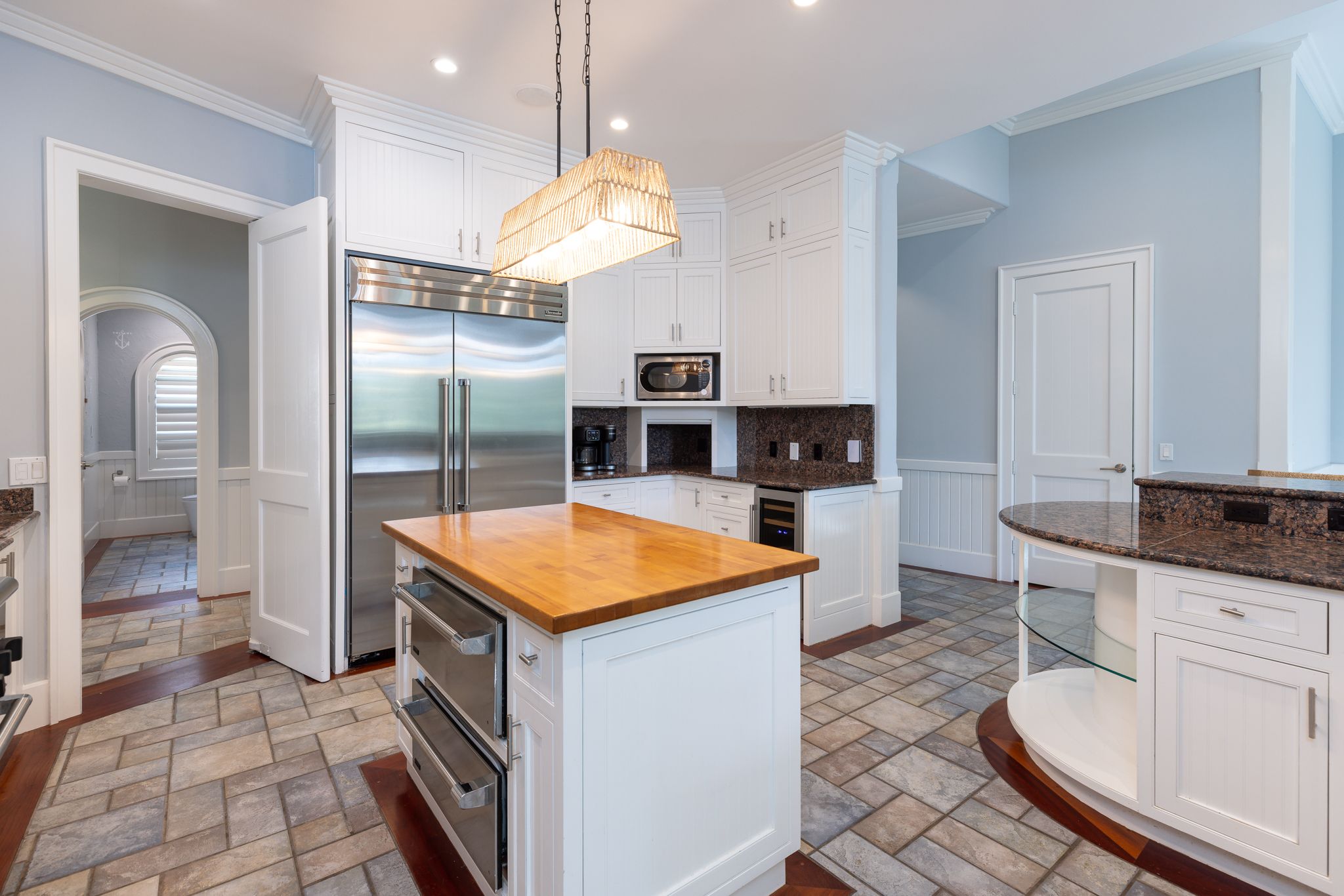 White cabinetry and a butcher-block island in the chef’s kitchen
