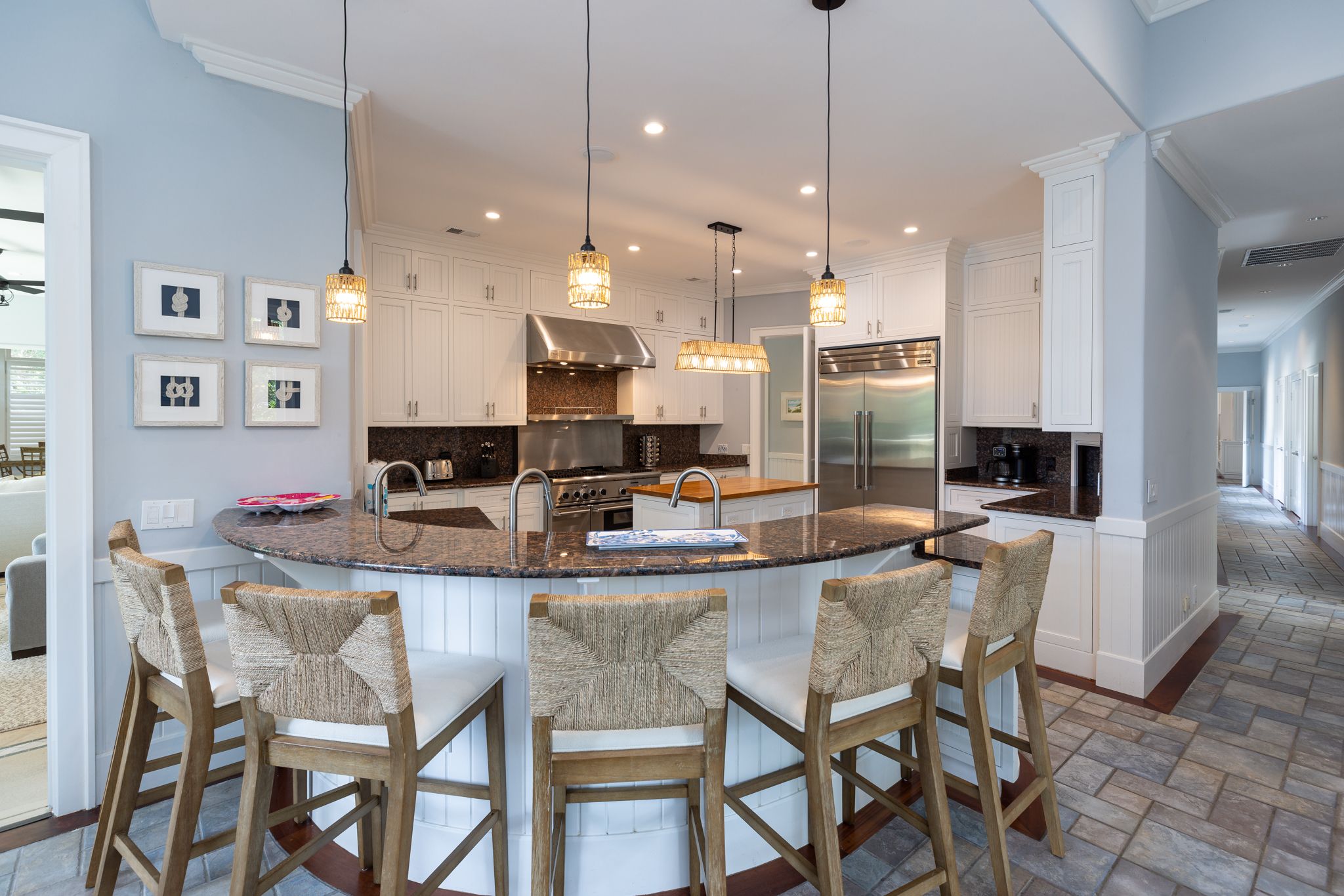 Chef's kitchen island with rattan barstools and warm wood counters at the Palmetto Dunes estate