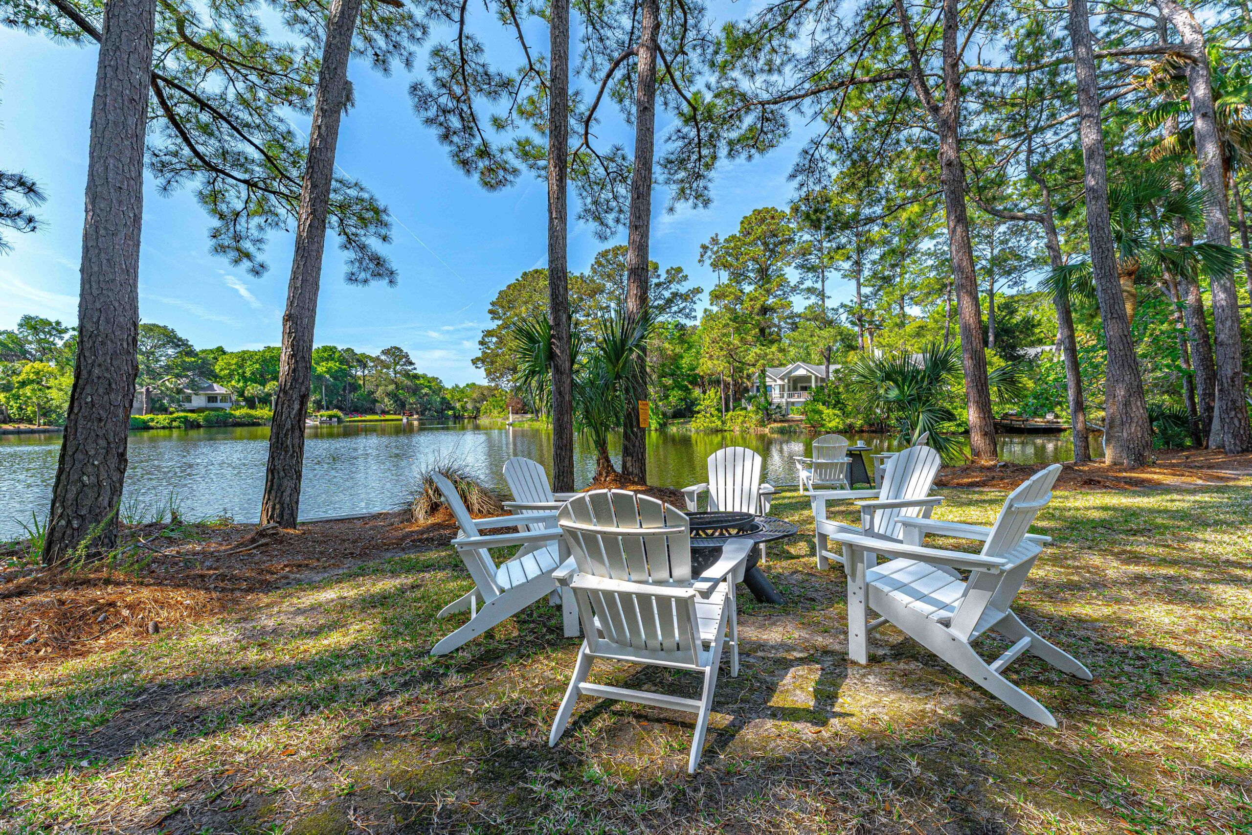 White Adirondack chairs around a fire table at the lagoon's edge in Palmetto Dunes, Hilton Head Island