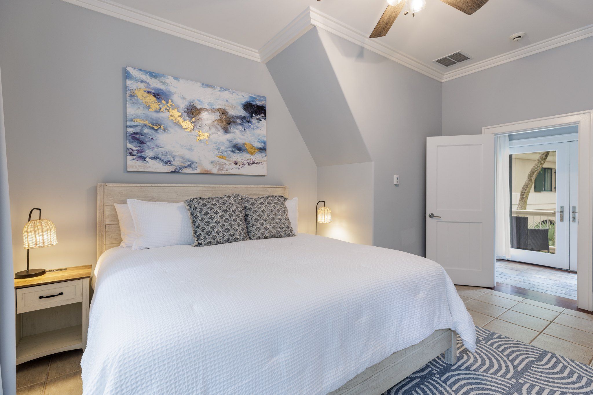 King bedroom suite with a coastal painting and adjoining bath