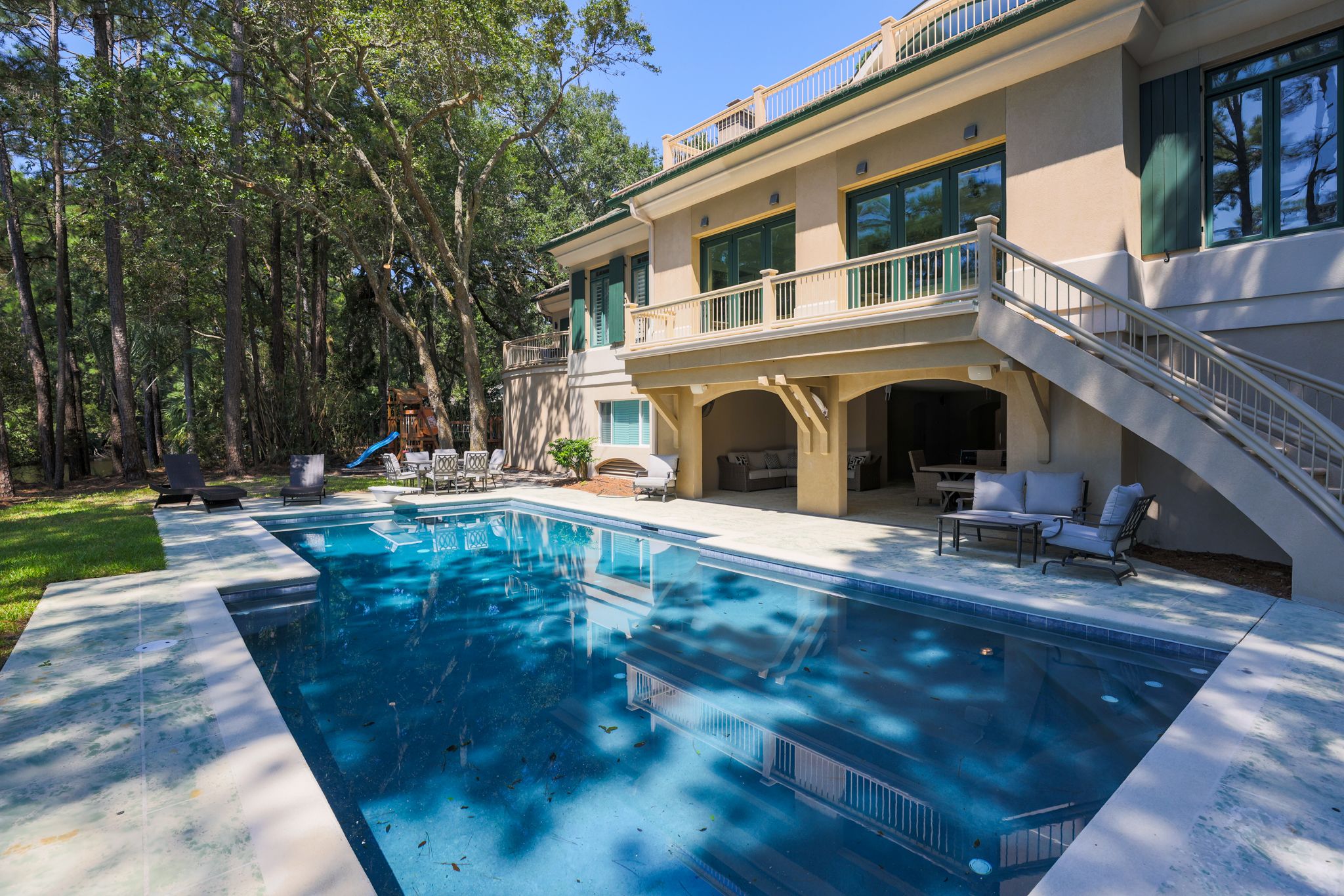 Private pool framed by the arched lanai of the estate inside gated Palmetto Dunes